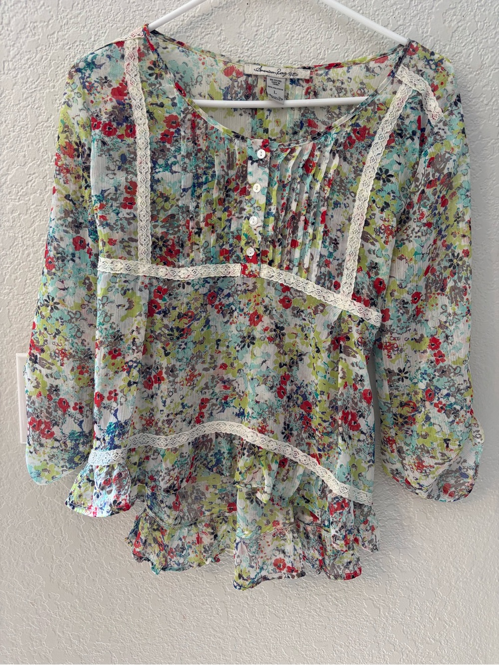 American Rag  Sheer floral peasant blouse with lace trim and pintuck detail.